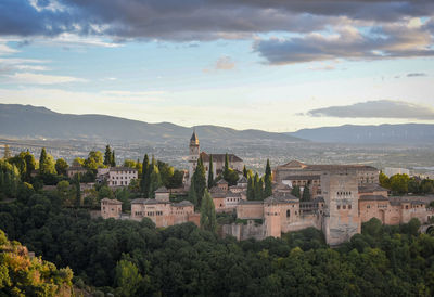 View of townscape by mountains against sky