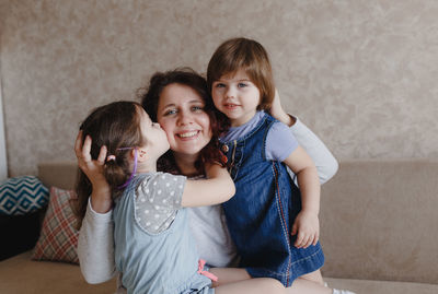 Portrait of happy friends sitting on floor