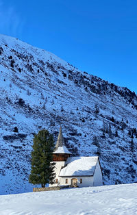 Scenic view of snowcapped mountains against clear blue sky