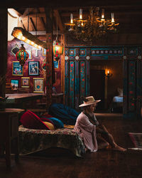 Side view of woman sitting on sofa at home