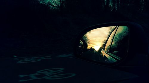 Reflection of cars over road on side-view mirror