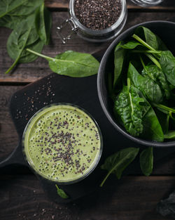 Glass of homemade healthy green smoothie with fresh baby spinach