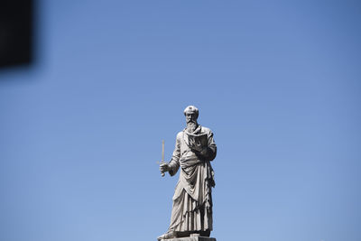 Low angle view of statue against blue sky