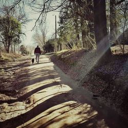 Rear view of a man walking on road