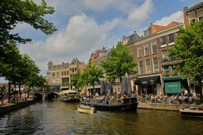 Boats in canal amidst buildings in city