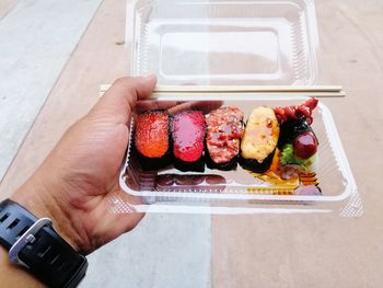 High angle view of hand holding food on table