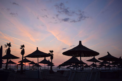 Silhouette of straw umbrellas at sunset on the beach