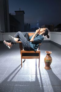 Side view of man smoking cigarette on building terrace