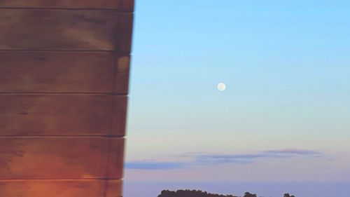 Low angle view of moon against blue sky