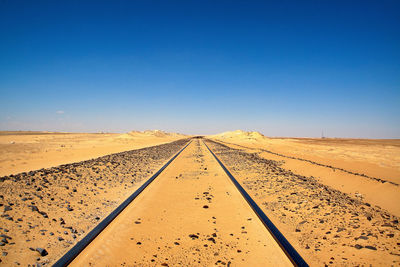 Road at desert against clear sky