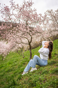 Rear view of woman sitting on grassy field