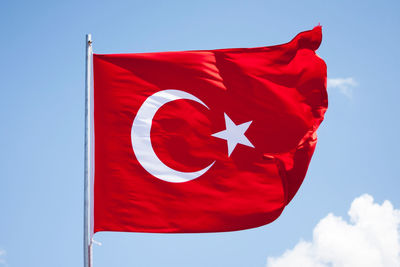 Low angle view of flag against blue sky