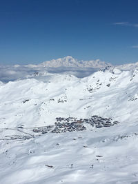 Scenic view of snowcapped mountains against blue sky