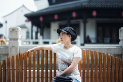 Woman looking away while sitting on bench