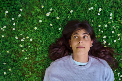 Portrait of young woman lying on grass