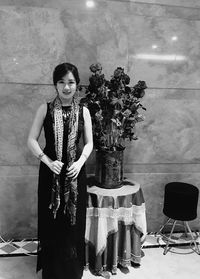 Young woman standing in front of wall