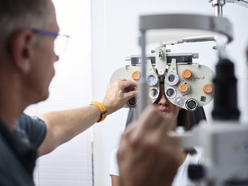 Optometrist examining young woman's eye