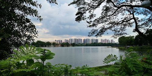 Scenic view of lake against sky in city