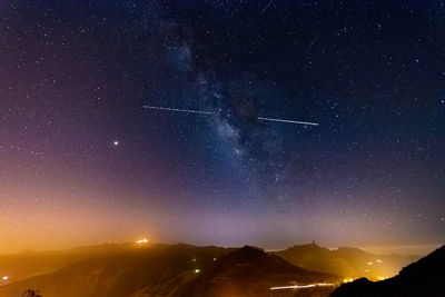 Scenic view of mountains against sky at night