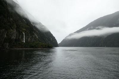 Scenic view of river and mountains against sky