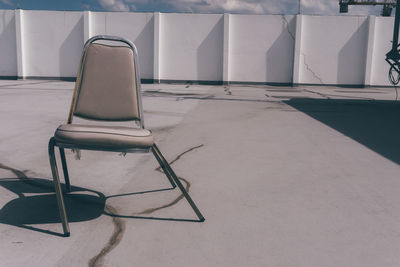 Empty chairs and table against wall