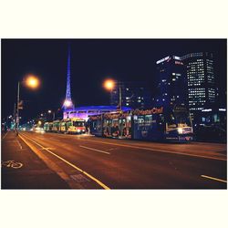 Light trails on city street against clear sky at night