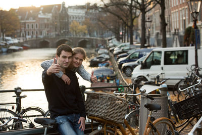 Young couple with bicycle by railing in city