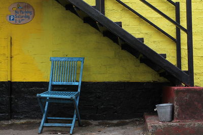 Empty chairs against yellow wall