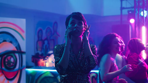 Portrait of young woman standing at music concert