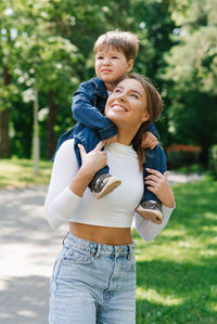 Mom and son are actively playing, having fun outdoors in the summer in the park. happy motherhood