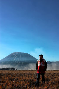 Full length of man standing on field against sky