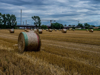 Hay bales on field against sky