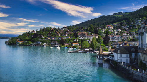 Scenic view of river by town against sky