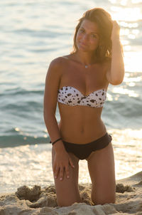 Woman standing on beach in front of sea