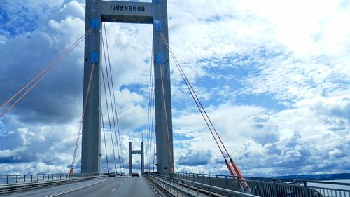 View of suspension bridge against cloudy sky