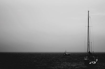 Sailboat sailing on sea against clear sky