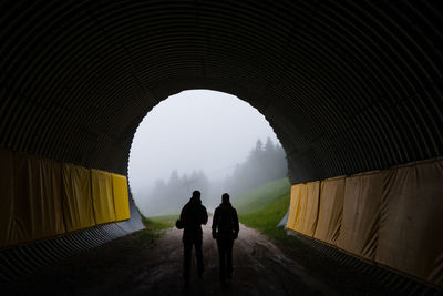 Rear view of people traveling in tunnel