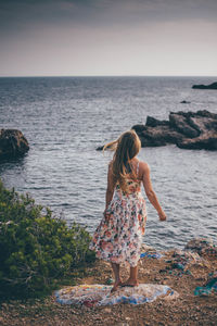 Rear view of girl standing at beach