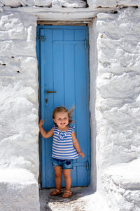 Full length of cute girl standing by door