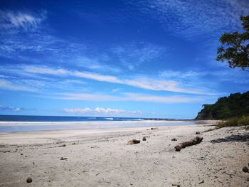 Scenic view of beach against blue sky