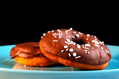 Close-up of donut on table against black background