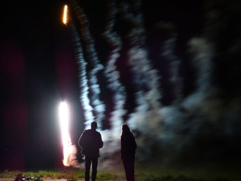 Rear view of woman standing at night