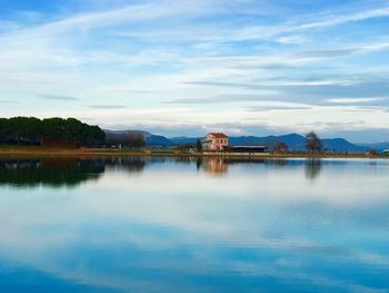 Scenic view of lake by buildings against sky