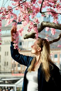 Woman looking at flowers on tree