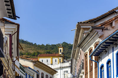 Buildings in town against clear blue sky