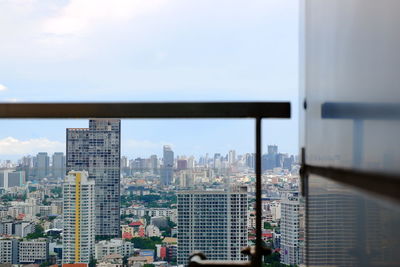 Modern buildings in city against sky seen through window