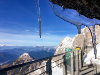 Close-up of icicles on mountain against sky