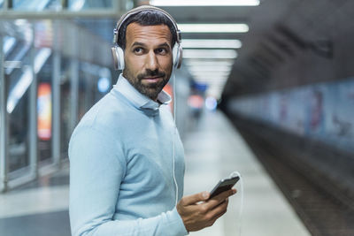 Businessman using smartphone at metro station