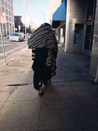 Rear view of people walking on street