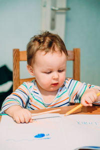 Portrait of cute boy sitting on table